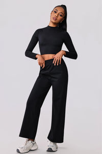 Black long sleeve crop top and wide leg activewear pants with white sneakers, perfect for gym or casual wear.