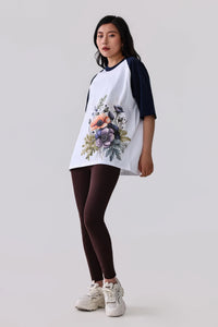 Floral print raglan t-shirt with navy sleeves, paired with dark leggings and white sneakers for activewear