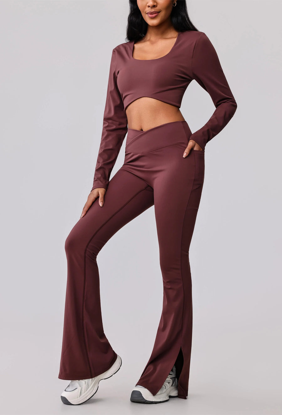 Women's burgundy activewear set with long sleeve crop top and flared leggings, perfect for yoga or gym workouts.