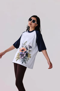Woman in white and navy raglan tee with floral print, styled with leggings and sunglasses for activewear look