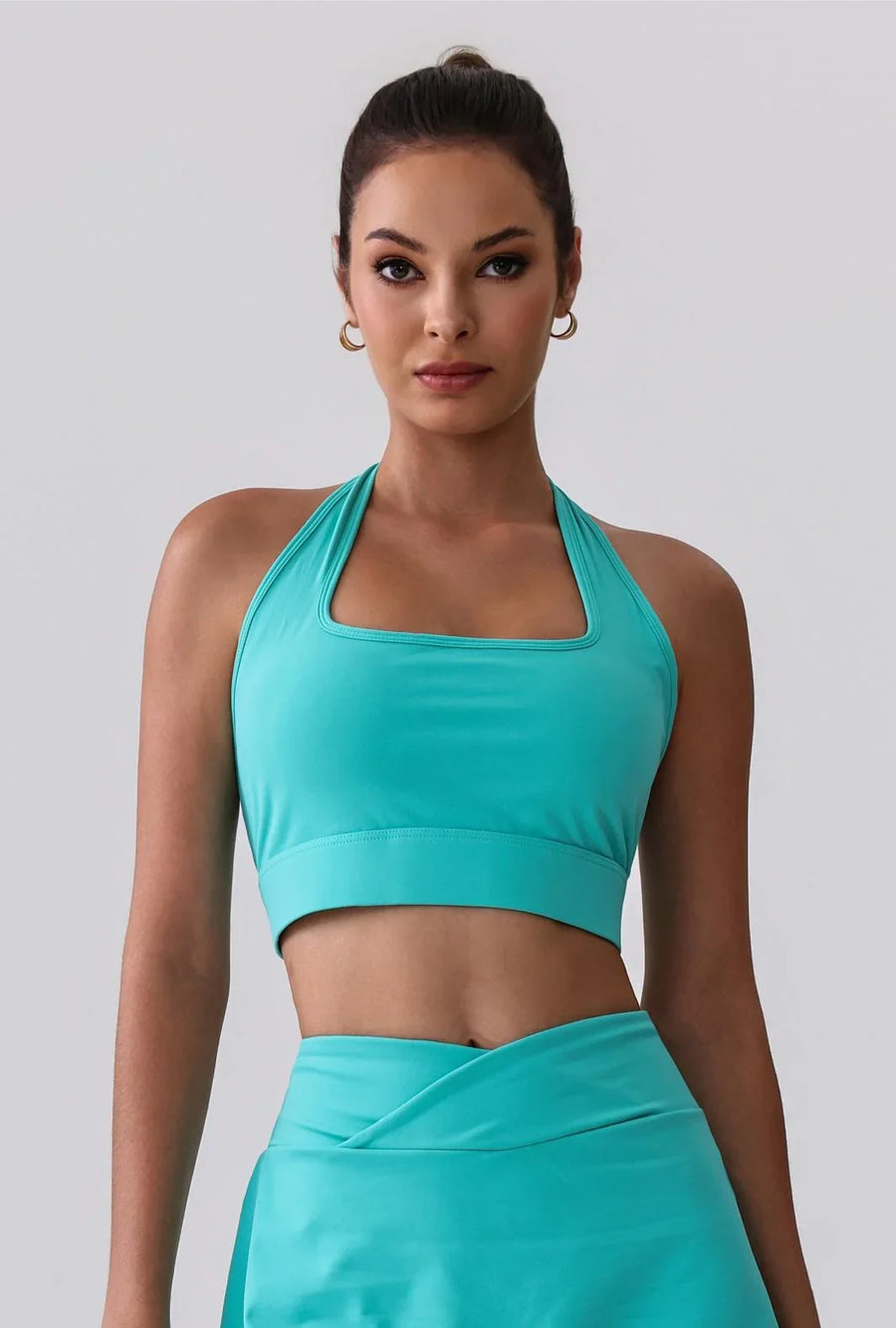 Teal halter sports bra and matching high-waist leggings for workout or everyday wear