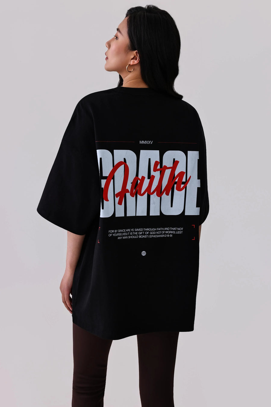 Black oversized graphic tee with 'Faith' print, activewear style, paired with leggings for casual or workout wear.