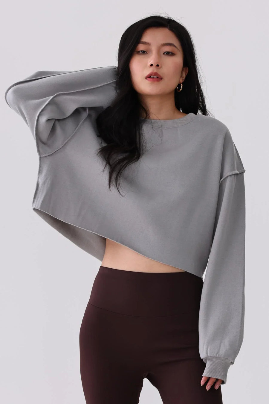 Gray cropped sweatshirt with balloon sleeves paired with high-waist leggings for activewear