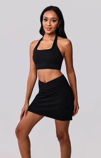 Black halter sports bra and matching wrap skirt activewear set for gym or everyday wear