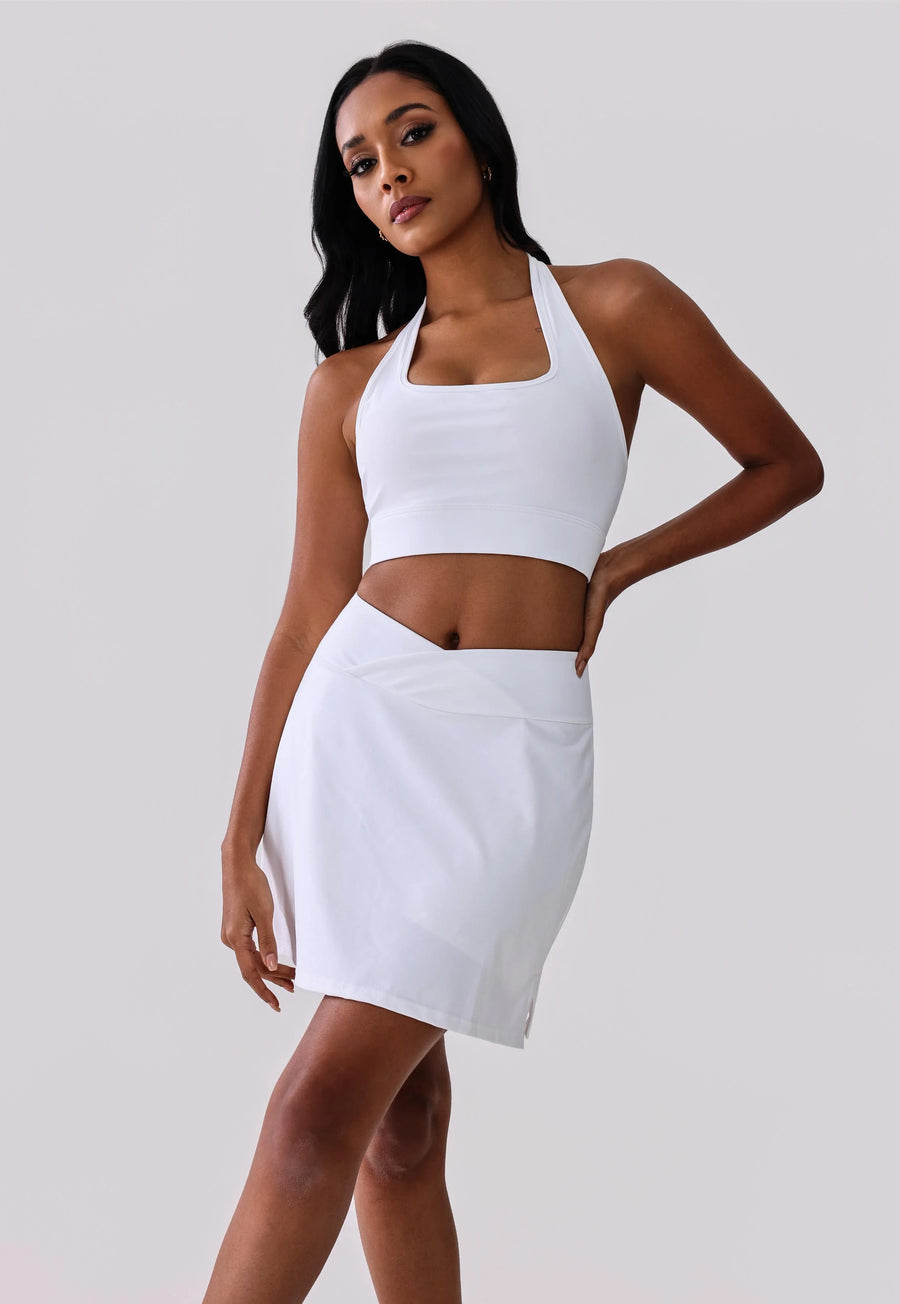 White activewear set with crop top and wrap skirt for yoga or gym workouts