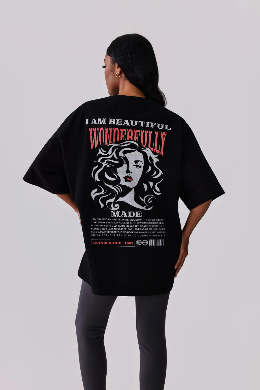 Black oversized graphic tee with 'I Am Beautiful Wonderfully Made' print, paired with leggings for activewear