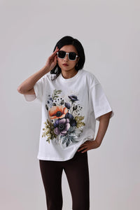 White floral graphic tee with purple and orange flowers, paired with dark leggings for activewear style