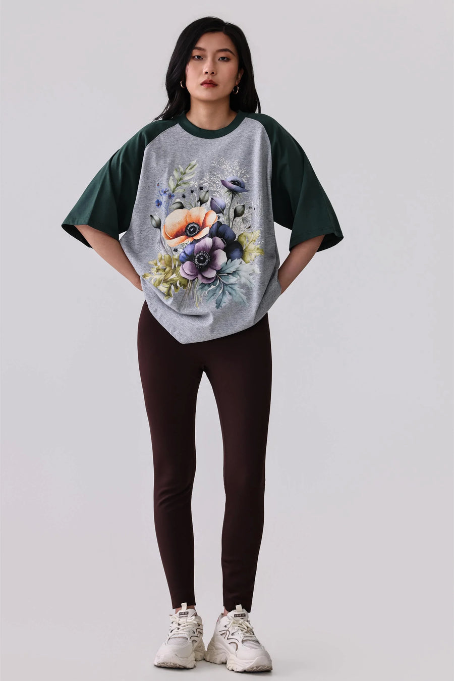 Floral print raglan tee with dark green sleeves, paired with brown leggings and white sneakers for activewear